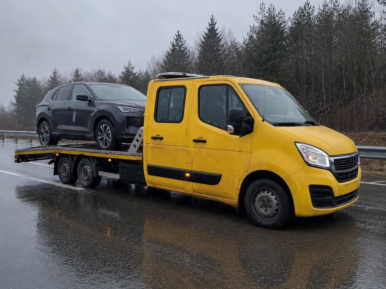 Holowanie srebrnego SUV-a na lawecie w deszczu – Otwock